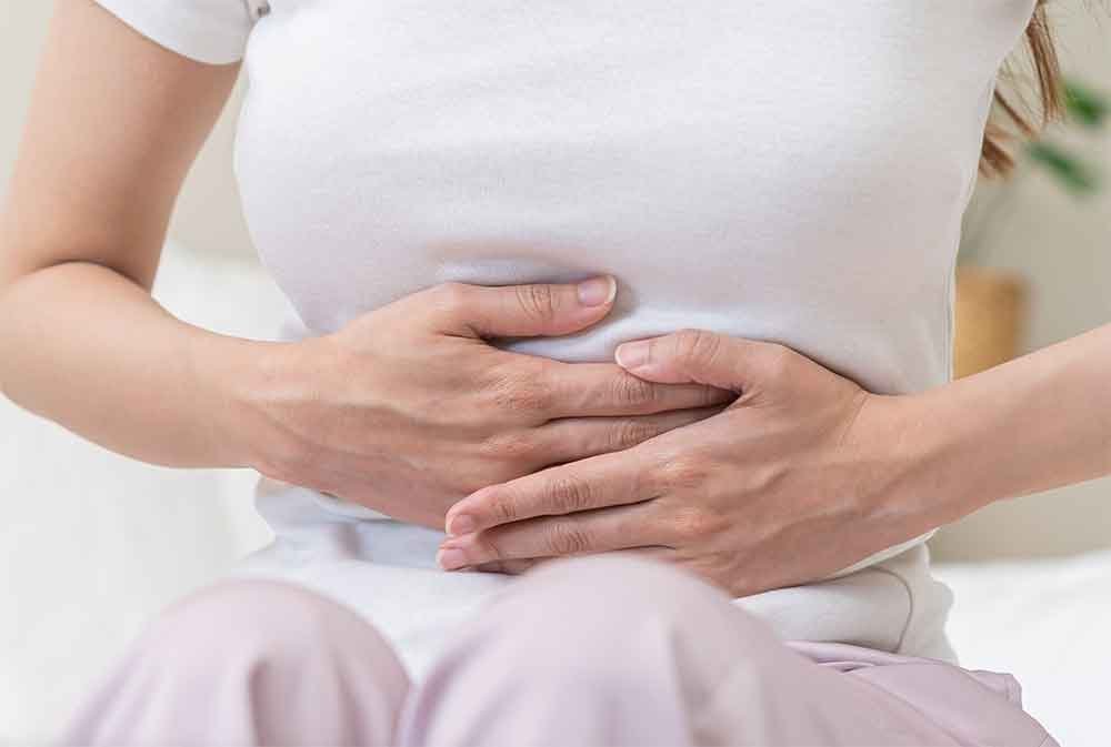 Person holding their stomach in discomfort